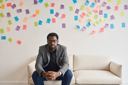 A businessman plans strategy on a couch in a London office