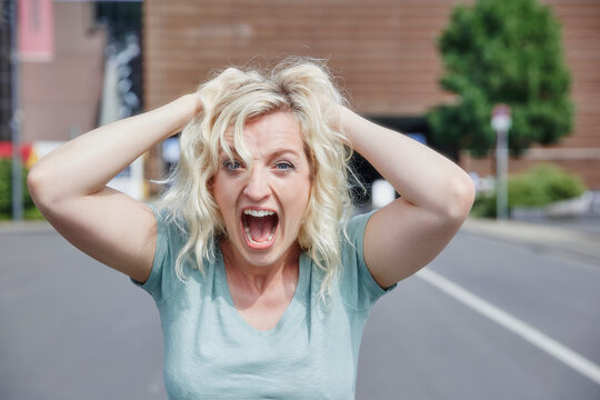 Portrait of screaming woman pulling her hair