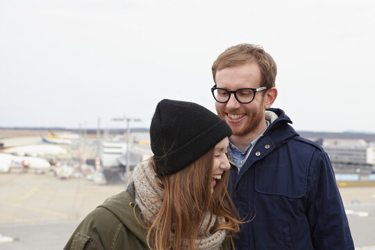 Germany, Cologne, Mid adult man and teenage girl at airport, smiling