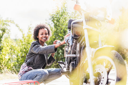 Young woman cleaning her motorcycle