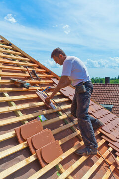 Germany, Baden-Wuerttemberg, Stuttgart, Mid adult man measuring roof tile