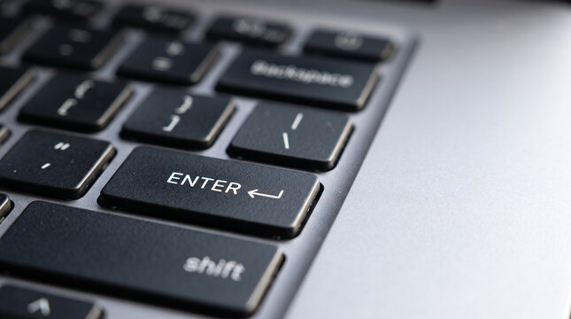 Close up on a laptop keyboard, focusing on the 'Enter' and 'Shift' keys.