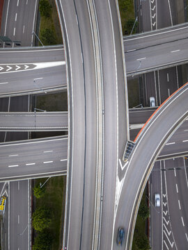 Aerial view of a complex highway interchange with multi-level roads, lane markings, and surrounding greenery in Gothenburg, Vastra Gotaland County, Sweden.