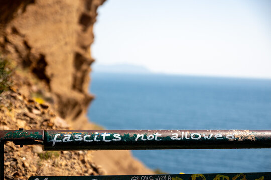 Graffiti Message on Coastal Cliffside Railing