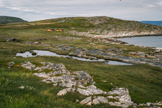 Pristine arctic tundra terrain with small tarns and rocky outcrops along the ocean coast on Mager&oslash;ya island near Nordkapp, Finnmark, Norway