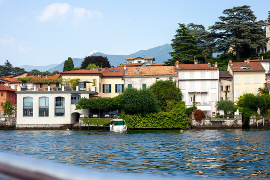 Charming Lake Como Shoreline Houses with Boat Dock and Mountains Background Italy.