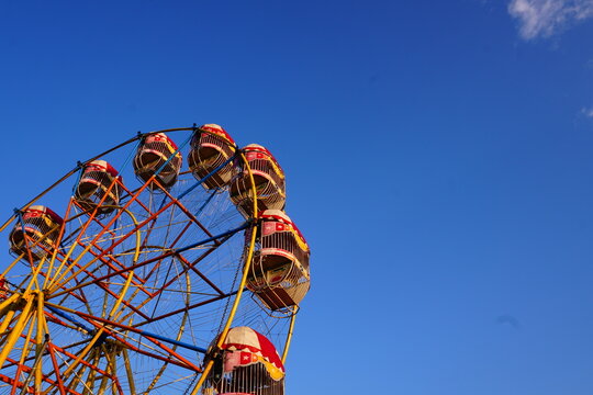 Ferris Wheel with Colorful Gondolas Against a Clear Blue Sky