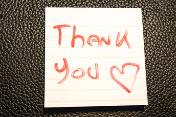 A handwritten note with the text Thank You  on it. © Sonny
