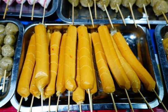 Orange Sausage Skewers Displayed at a Food Stall