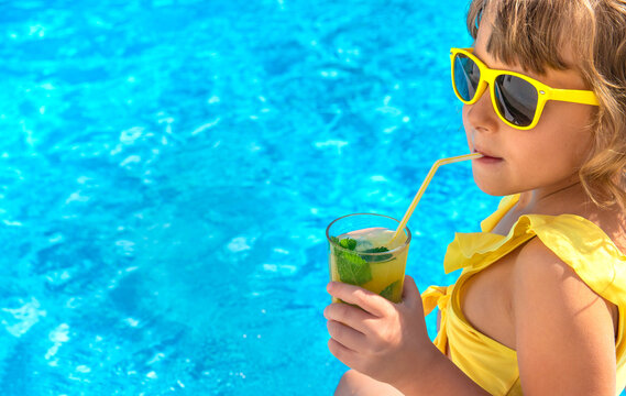 Child with juice in the pool. Selective focus.