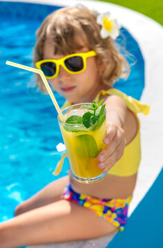 Child with juice in the pool. Selective focus.