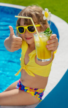 Child with juice in the pool. Selective focus.