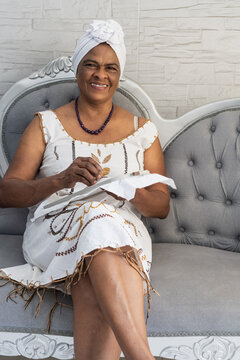 Senior baiana woman embroidering traditional costume fabric