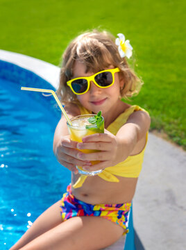 Child with juice in the pool. Selective focus.