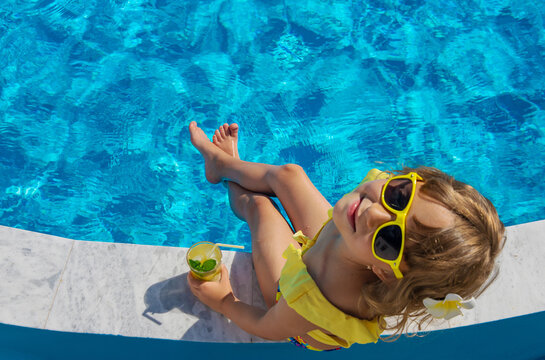 Child with juice in the pool. Selective focus.