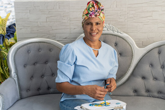 Woman making handmade jewelry, smiling and enjoying a hobby
