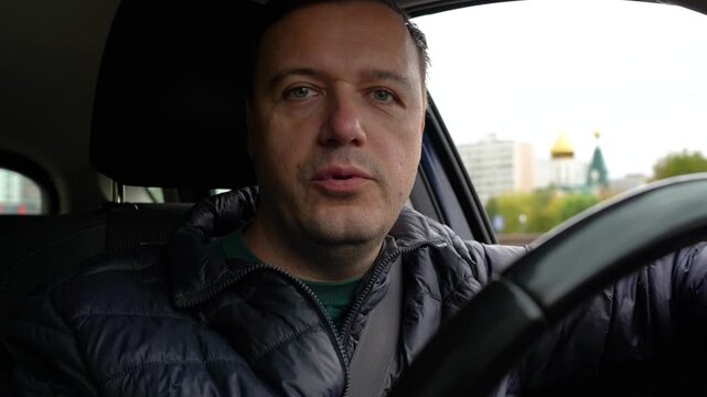 Middle-Aged Man Discussing Life While Driving Through City Streets in His Vehicle