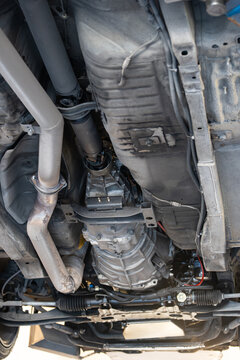 Wide view from directly below showing the manual transmission, central driveshaft, exhaust system, and front suspension setup