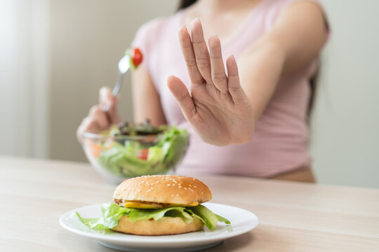 A person who avoids eating high-calorie junk food in high calories to control cholesterol and sugar during a diet session for weight loss and good health