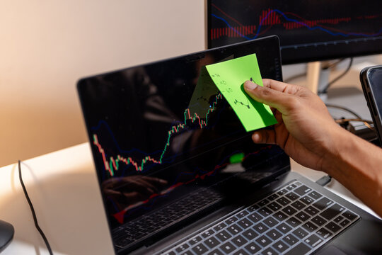 Professional stock trader reviewing market charts with sticky notes across multiple monitors, laptop, and tablet to analyze price trends, plan trading strategies, and manage investment decisions.