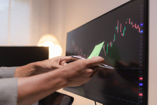 Professional stock trader reviewing market charts with sticky notes across multiple monitors, laptop, and tablet to analyze price trends, plan trading strategies, and manage investment decisions.