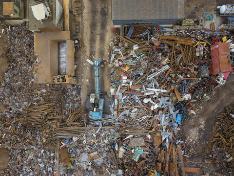 Aerial view of an excavator sorting scrap metal at a recycling facility in Agnesberg, Gothenburg, Vastra Gotaland County, Sweden.