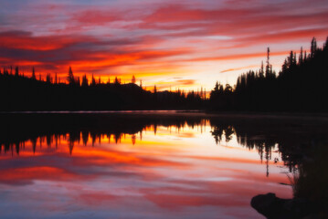 Fototapeta premium Fiery sunset over alpine lake reflection