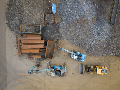 Aerial view of heavy machinery and scrap metal piles at an industrial recycling site in Agnesberg, Gothenburg, Vastra Gotaland County, Sweden.