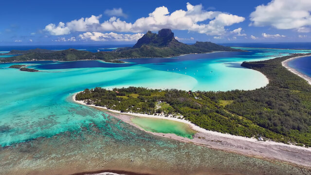 Luxury resort photo of French Polynesia tropical paradise island Bora Bora in Pacific Ocean. Beautiful photography with
sandy beach, palm trees, coral reef, azure ocean, sky 
with clouds on horizon. 