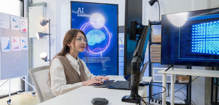 Caucasian woman working with artificial intelligence on laptop in high-tech office