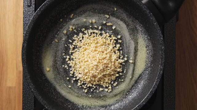 Chopped almonds are added to melted butter in frying pan. Chopped almonds toast until golden, crisp and nutty. Use chopped almonds as topping for salads, vegetables, rice, couscous, pasta or fish.