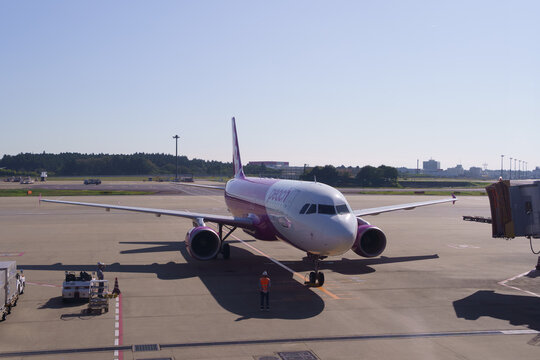 Peach Aviation Airbus A320 is guided across the apron by a ground marshaller on November 4, 2024 in Narita International Airport, Narita, Japan.