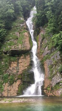 Scenic view of Schreinbach waterfall cascading down the rocky cliffs into K&ouml;nigssee, seen during a boat trip on the crystal-clear lake in Berchtesgaden National Park, Bavaria, Germany. 