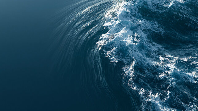 Powerful ocean wave cresting with white foam in deep blue water.