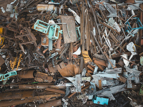 Aerial view of a scrap metal yard in Agnesberg with piles of rusted iron beams, metal sheets, and discarded industrial machinery in Gothenburg, Vastra Gotaland Count, Sweden.