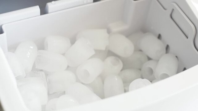 Opening home ice maker machine lid and taking fresh ice cubes