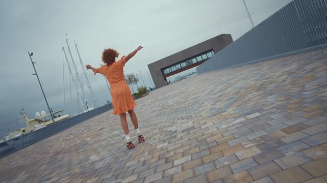 Beautiful red haired young woman with rollerskates having fun outdoors