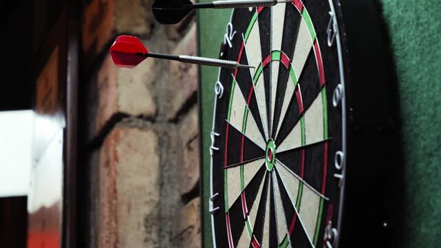 Close-up video of a dart hitting a dartboard during a game of darts in a bar. High quality 4k footage