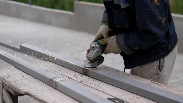 worker meticulously sanding wooden planks outdoors on a sunny construction site, showcasing focused and industrious expression in a close-up, slightly elevated angle, with gray and brown pl.
