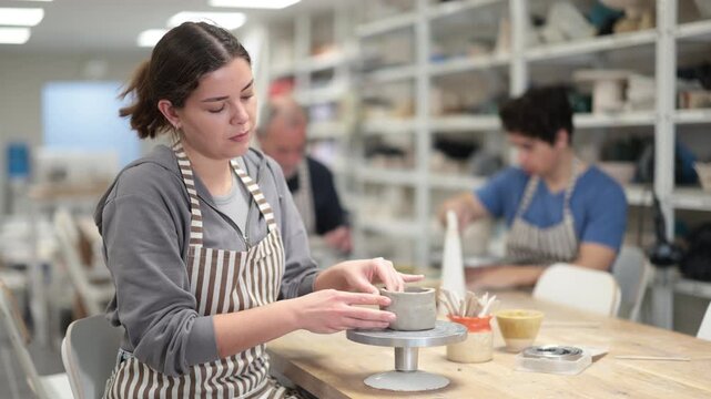 Young woman pottery workshop workers sculpt from raw clay. High quality 4k footage