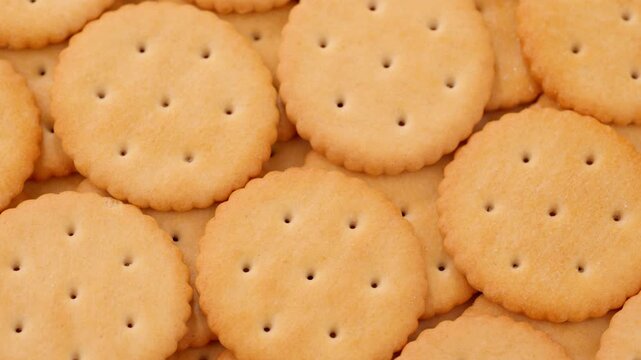 Macro shot of round salty cracker cookies. Snacks. Beer snack. Smooth rotation in a circle	
