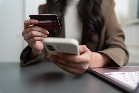 Professional woman holding a payment card and smartphone for identity verification, representing secure authentication, personal data protection, mobile banking, online payment and digital security.