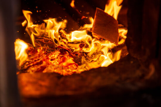 Taichung, Taiwan, January 28, 2025: Close-up of a traditional Taiwanese temple ritual involving burning joss paper and devout worshippers.
