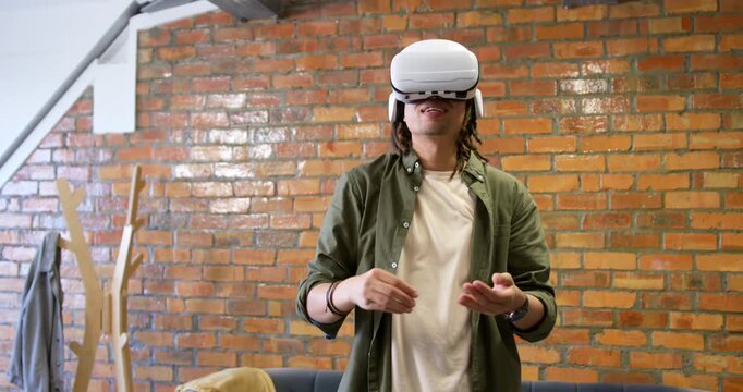 Man wearing VR headset following headset prompts, reaching, manipulating virtual UI in loft