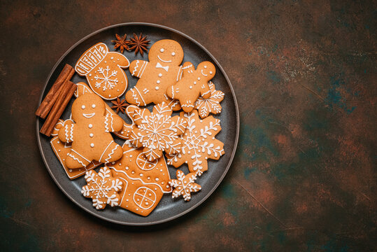 Christmas gingerbread cookies in a plate on dark grunge background, top view, flat lay, copy space