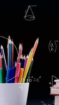 Mathematical equations floating against apple on stack of books and pencil stand