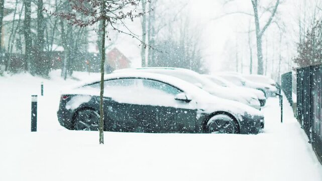 Parked vehicles buried under deep fresh snow during heavy blizzard in winter season. Automotive transport, cold weather conditions, and urban winter snowfall concept.