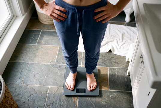 Top view of person standing on digital bathroom scale in bathroom setting