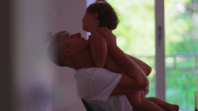 Mother with cancer embracing toddler child at home, sharing candid affectionate moment, expressing unconditional love, resilience, family bonding, caregiving and hope