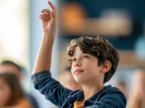 Child raising hand in classroom during lesson in school setting